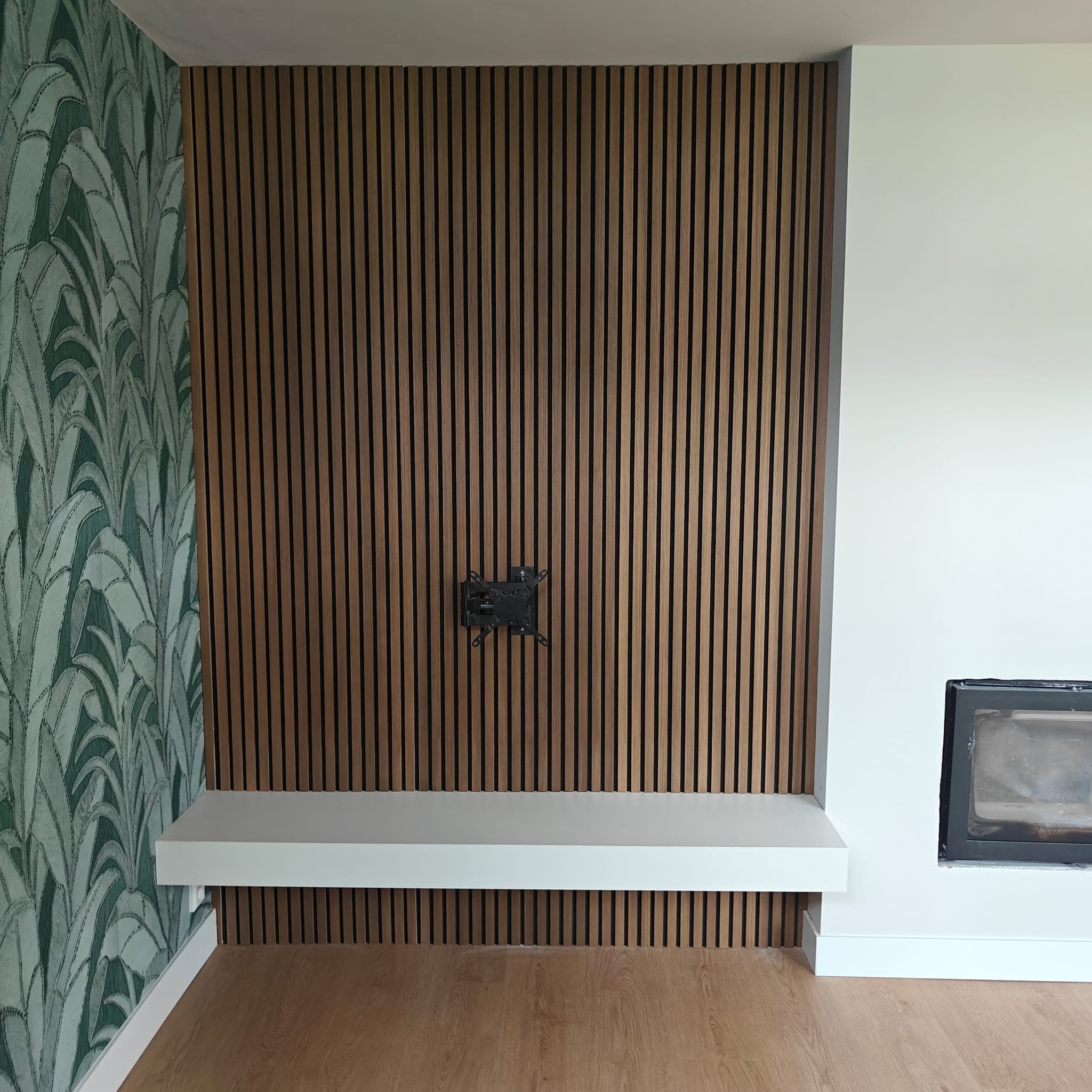 Warme woonkamer met maatwerk lattenwand en haard